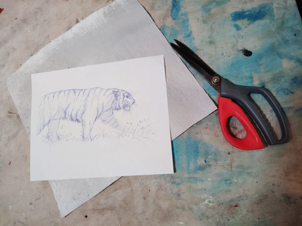 Hand-drawn tiger sketch on white paper, pen art by Sandro Gia, placed on textured background with scissors